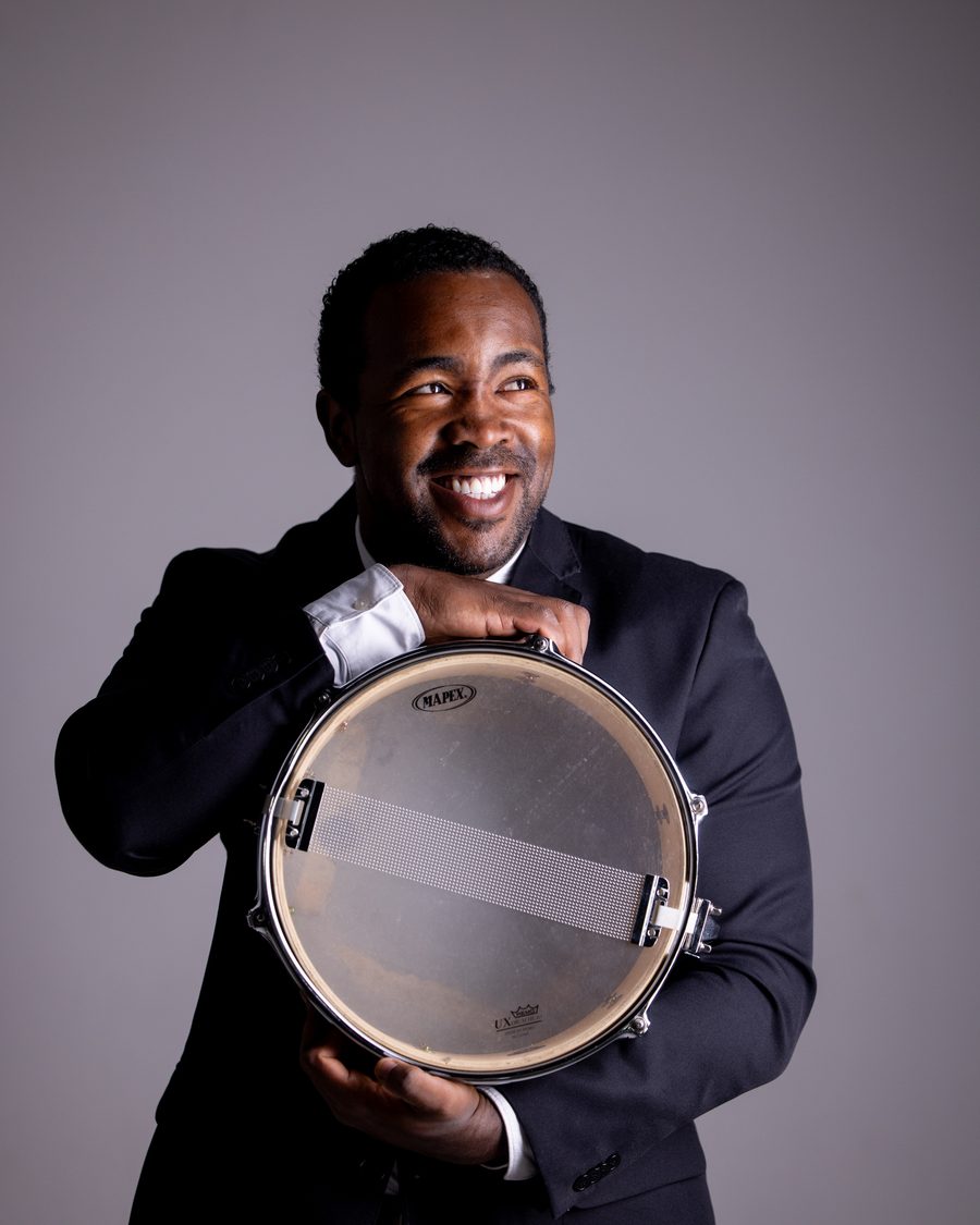 Josué Oliveira, professor de bateria e percussão da EArte, com uma caixa de percussão